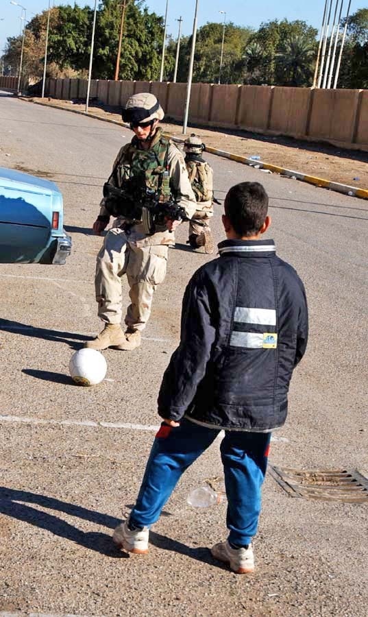 Spc. Eaton plays soccer with a young Iraqi boy