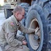 Spc. Jesse Campion fixes a tire on a truck