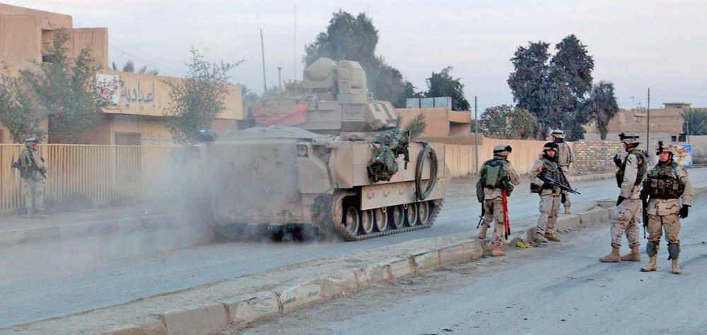 Soldiers walk alongside their wheels in Mamudiyah
