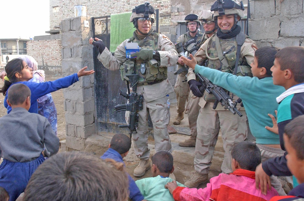 Soldiers pass out candy to children in Mamudiyah
