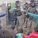 Soldiers pass out candy to children in Mamudiyah