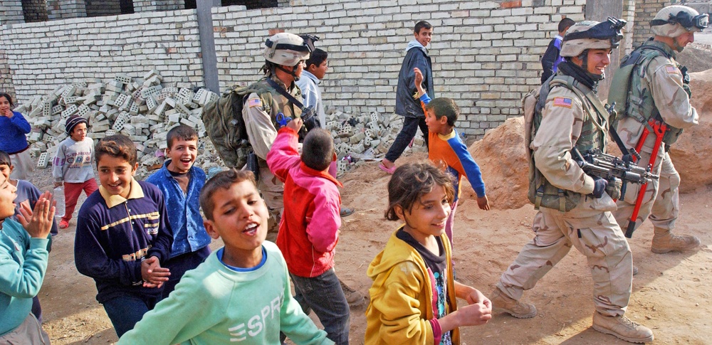 Soldiers walk with children in the streets