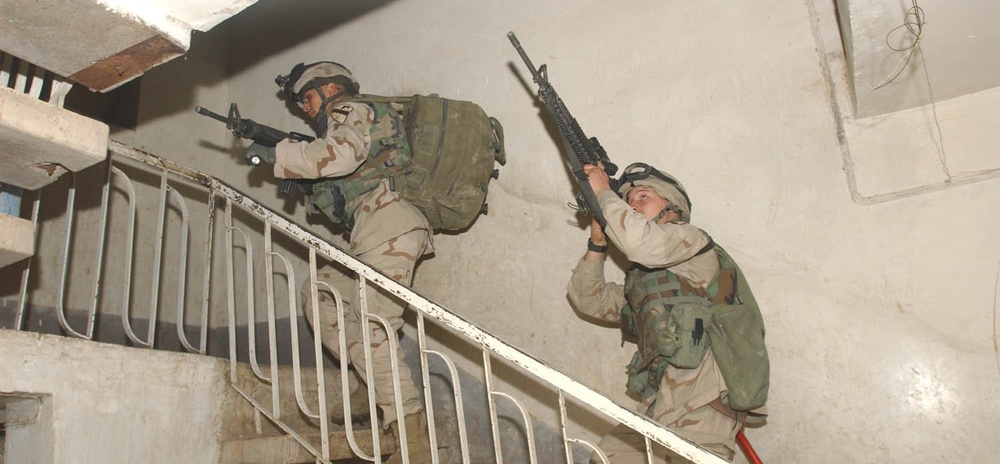 Soldiers take care in moving upstairs during a search