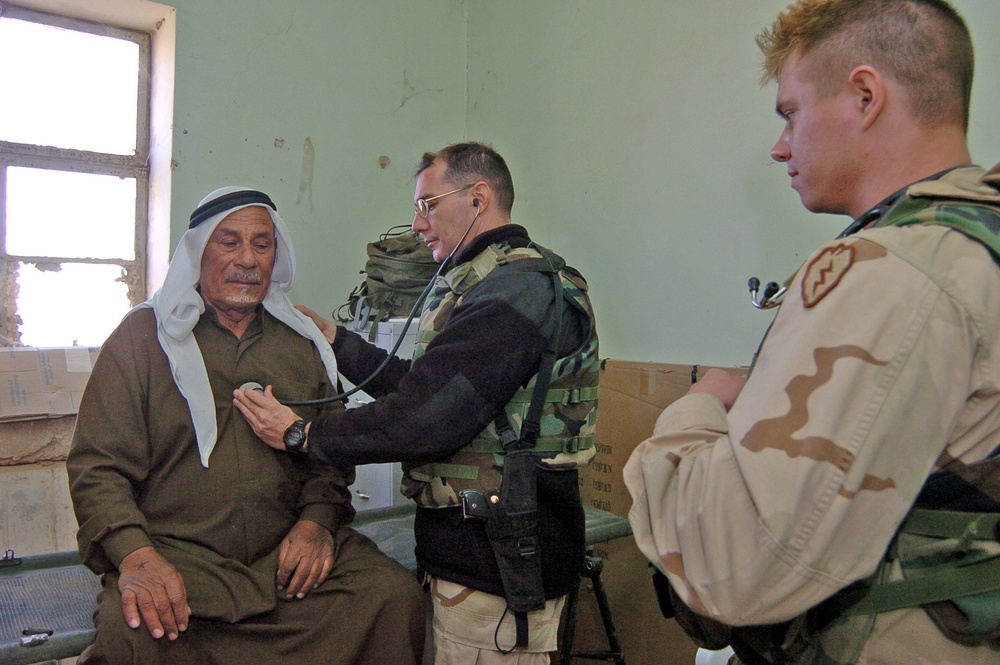 Maj. David Freel examines an Iraqi man