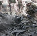 Explosive ordnance personnel examine debris in the crater