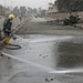 Baghdad firemen spray debris from the road