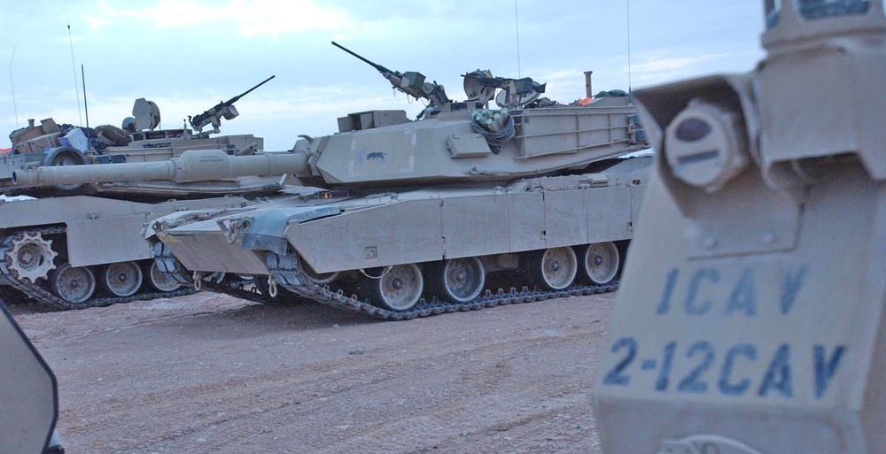 Abrams tanks refuel at a supply depot