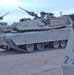 Abrams tanks refuel at a supply depot