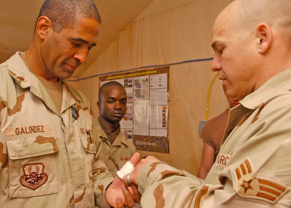 Senior Airman Weiss finishes bandaging Maj. Peter Galindez