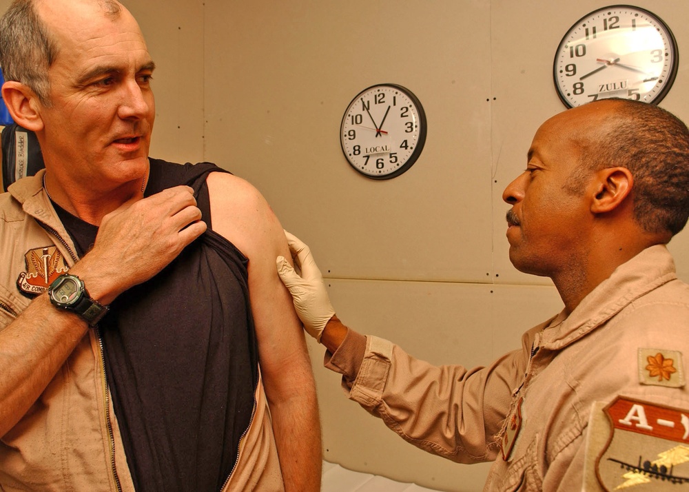 Maj. Lundy checks Lt. Col. Robin smallpox vaccination