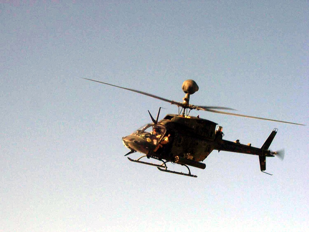 An OH58 Kiowa Warrior scout helicopter flys over