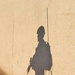 A paratrooper casts a long shadow on a wall