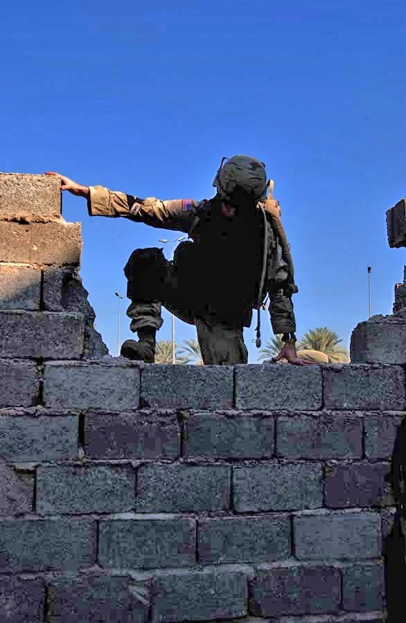 Pvt. Kris White scales a wall while on a patrol