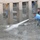 Two Iraqi workers struggle with a water hose