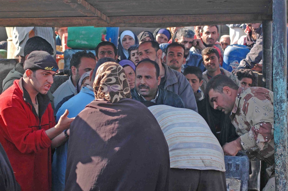 A long line of Iraqis wait for their turn to fill up on kerosene