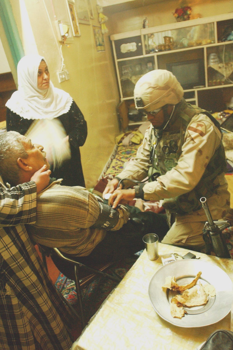 Sgt. Jimmy Raldiris checks vital sign of an Iraqi man