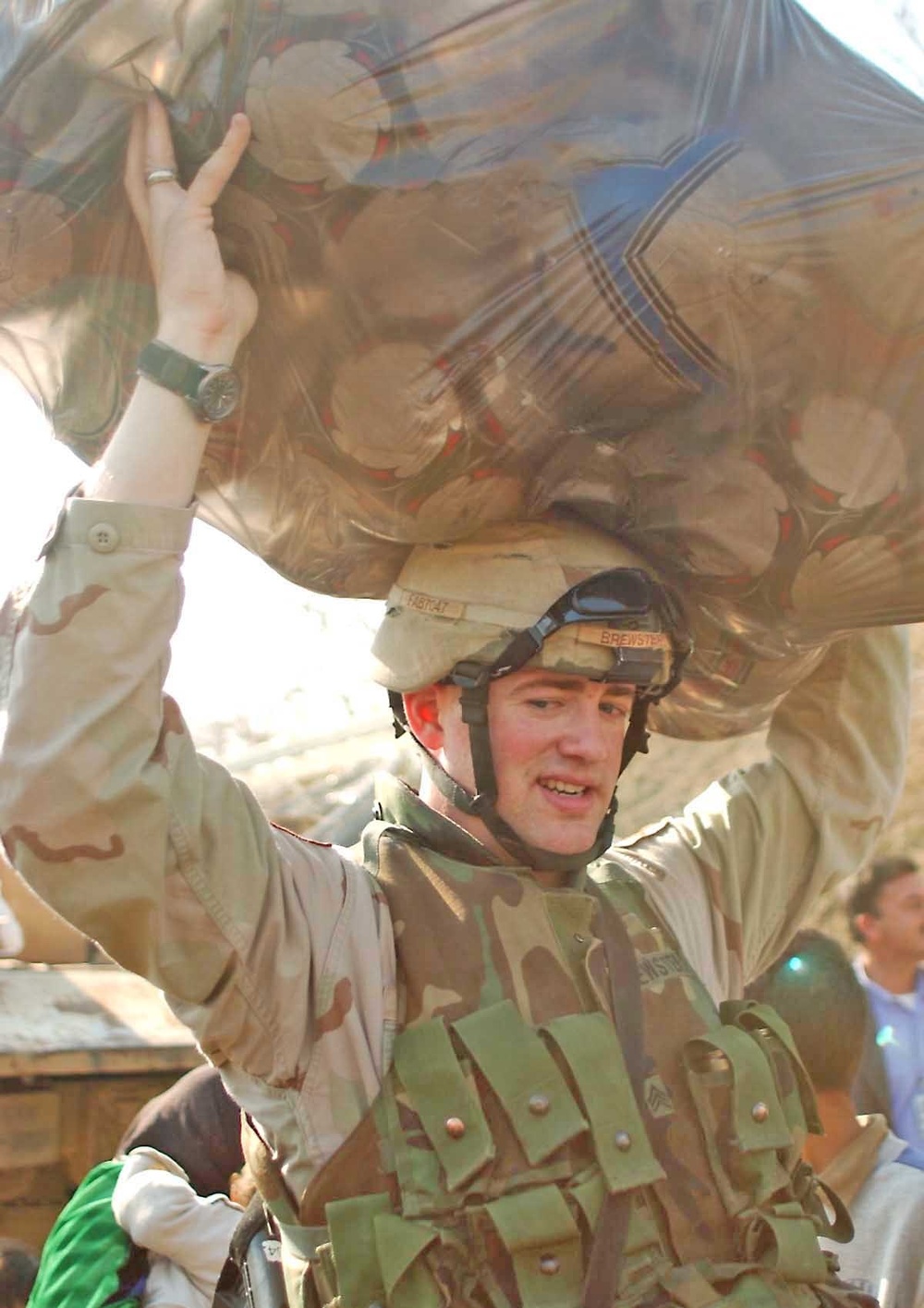 Sgt. Bradley Brewster balances a bag full of soccer balls