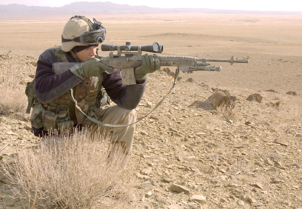 Spc. Jonathan Low scan the horizon from a hilltop