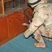 An Iraqi National Guardsman cuts the lock to a cabinet