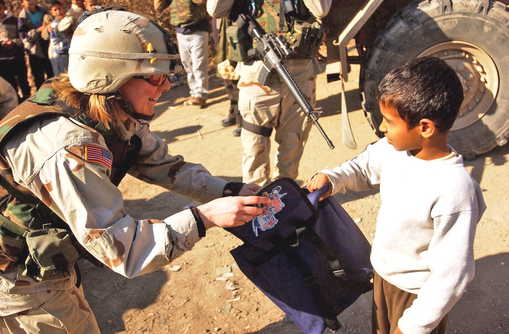 Capt. Willett hands out a backpack full of school supplies