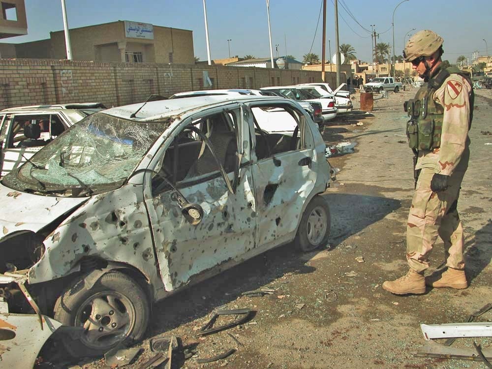 A Soldier looks over a vehicle that was destroyed