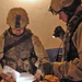 Soldiers inspect paperwork found in a house raided