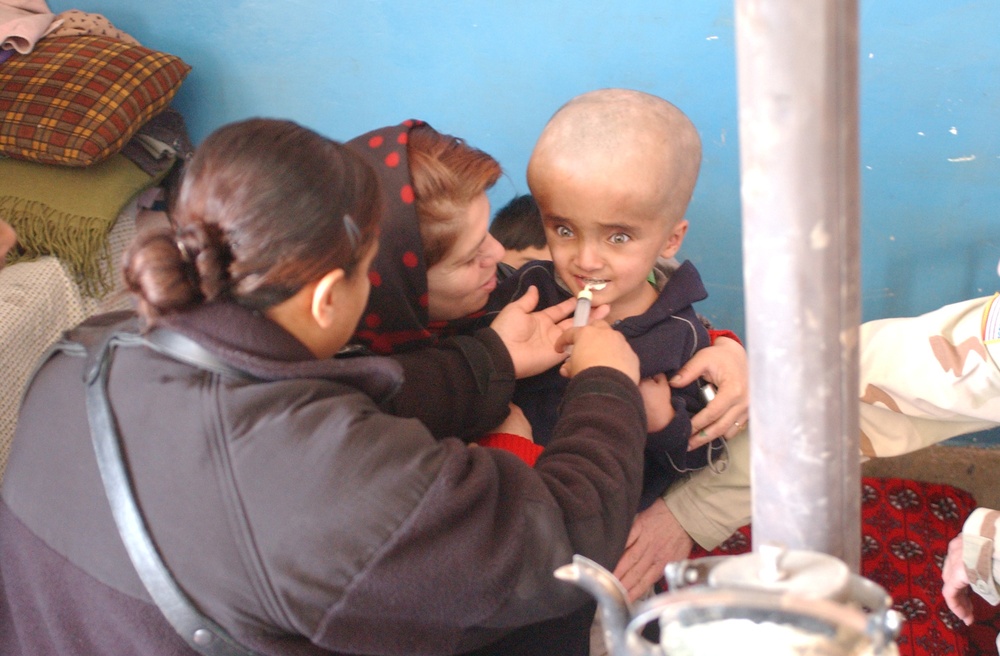 Spc. Jasmine Smith administers a dose of dewormer to Seyar