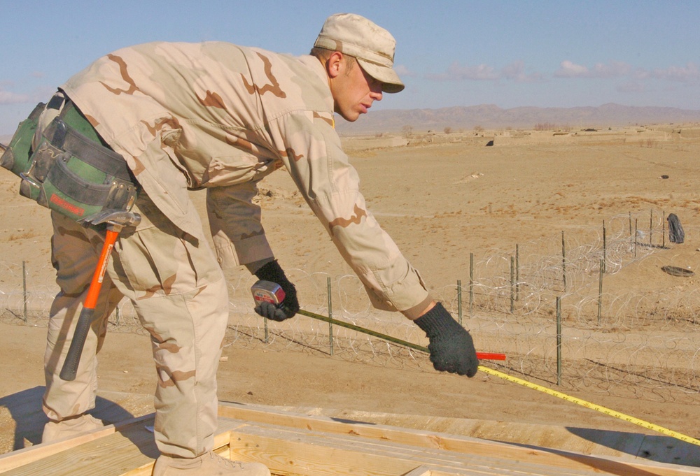 Spc. David Baker uses a tape measure to check the dimensions