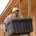 Pfc. Luis Flynn carries a box of office supplies