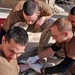 Spc. Tjalsma winces as Spc. Jesse Campion inserts an IV