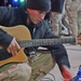 Spc. Christopher Lowry tunes up an acoustic guitar