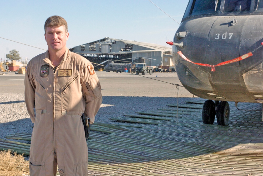 Staff Sgt. Glenn Stewart stands near one of 14 Chinooks