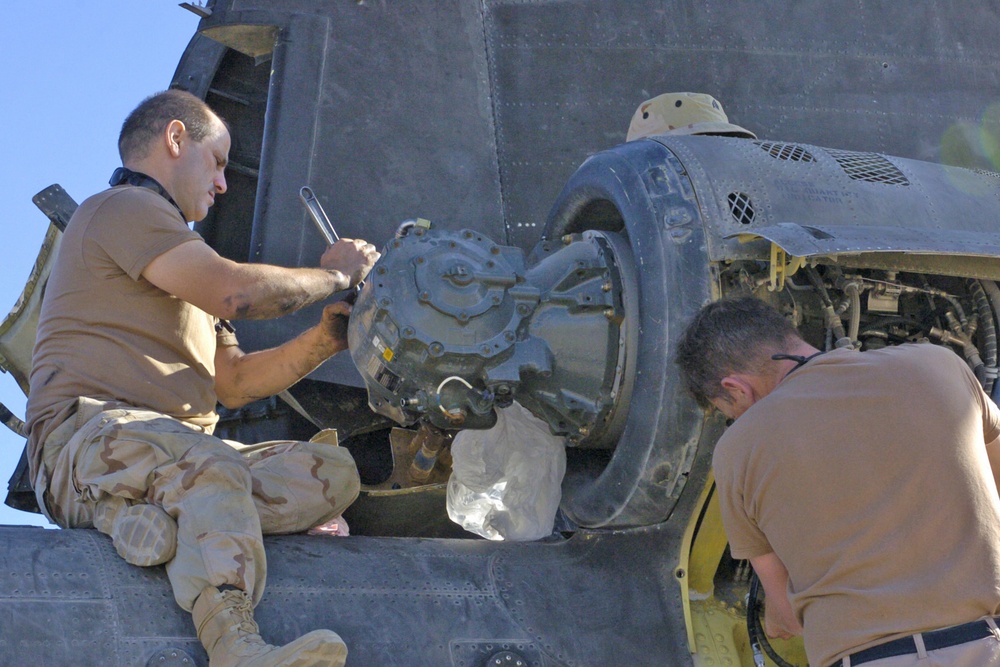 Mechanics replace an engine in one of 14 Chinook