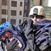 1st Sgt. Guden is almost hidden behind a stack of book bags