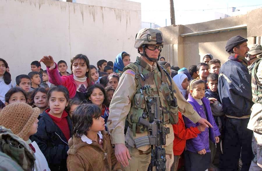 Pfc. Timothy Hall is surrounded by children