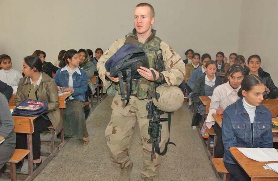 2nd Lt. Derek Reeves hands out book bags