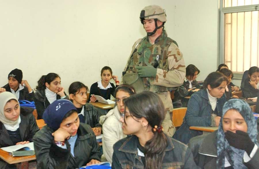 Sgt. Lanny Stottmeister helps distribute book bags