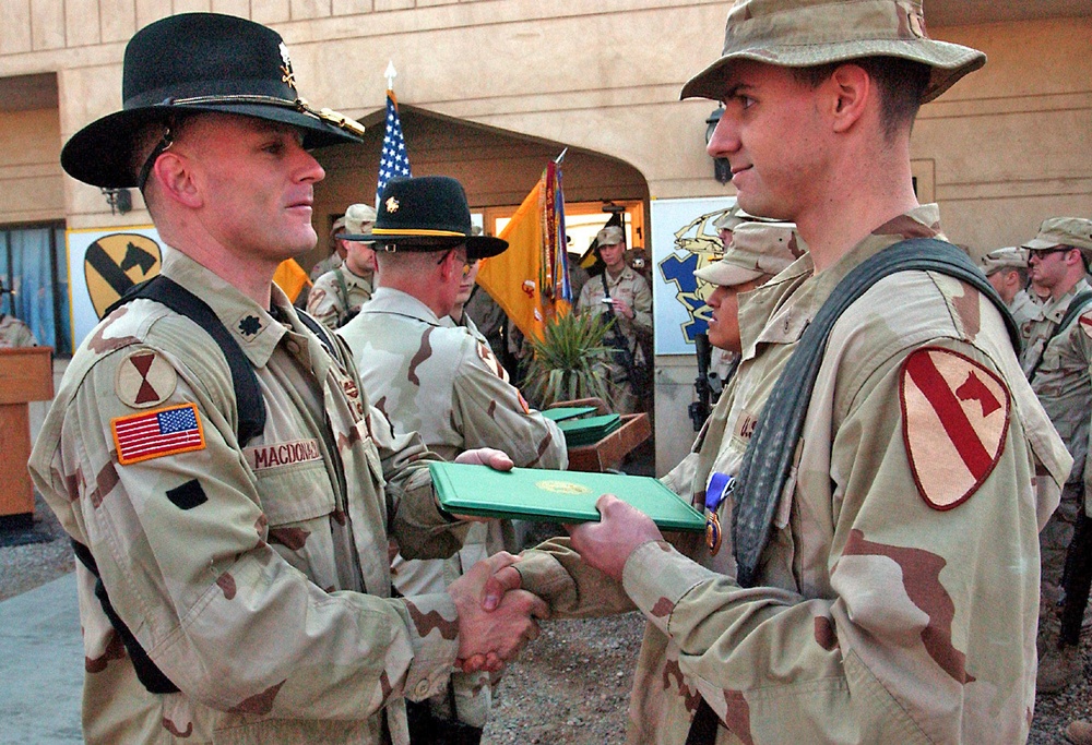 Lt. Col. Thomas MacDonald shakes hands with Spc. Matte