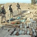 Soldiers inspect a weapons cache found during cordon