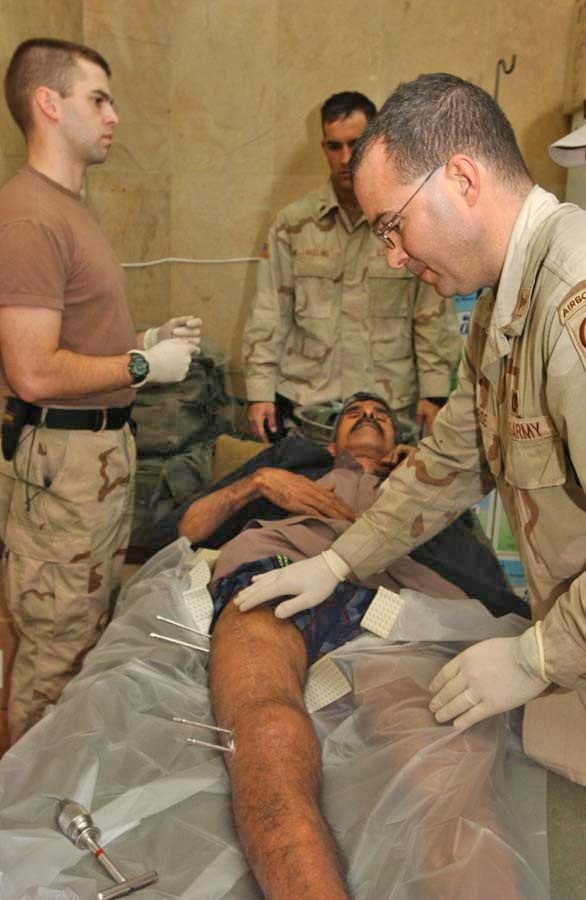 Maj. John Bride holds patient Kadaam Hassoun steady