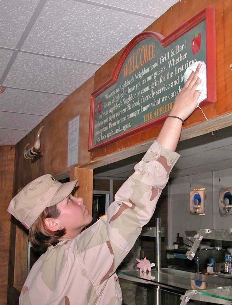 Spc. Raechel Avallone cleans off Applebees sign