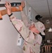 Spc. Ariana Vargas places a baseball bat back on its holder