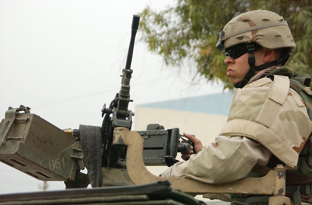 Spc. Jessy Nix scans a Baghdad street while pulling security