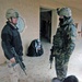 Soldiers guard two detainees at their patrol base