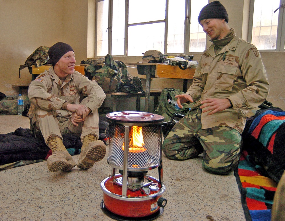 Soldiers pass time around a Kerosene heater