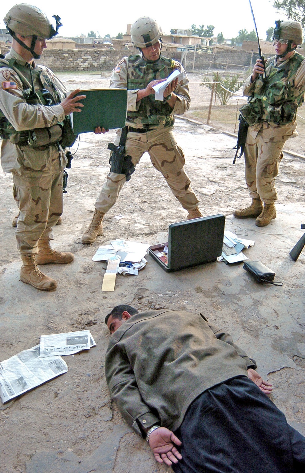 Soldiers search through the belongings of a suspect
