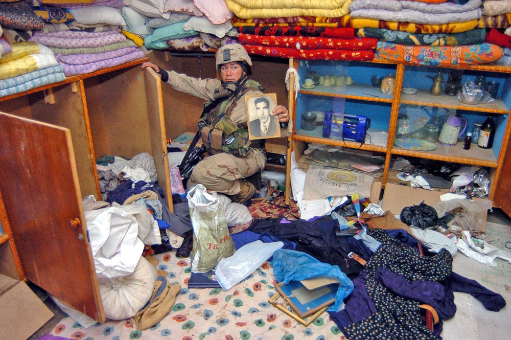 Sgt. Gonzalez holds up a photograph of an Iraqi man