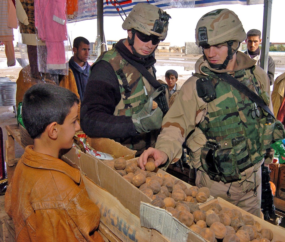Soldiers purchase items at an Arab market