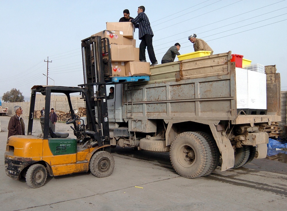 Iraqis load election ballots onto a truck