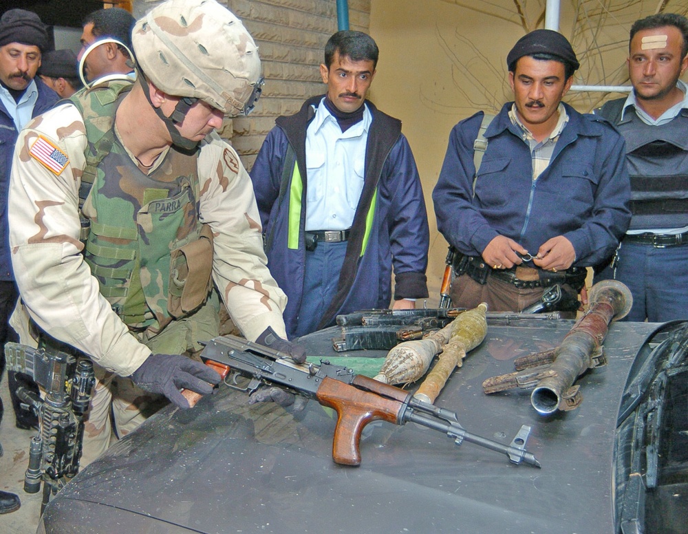 SSgt. Luis Parra spreads out a weapons cache founded